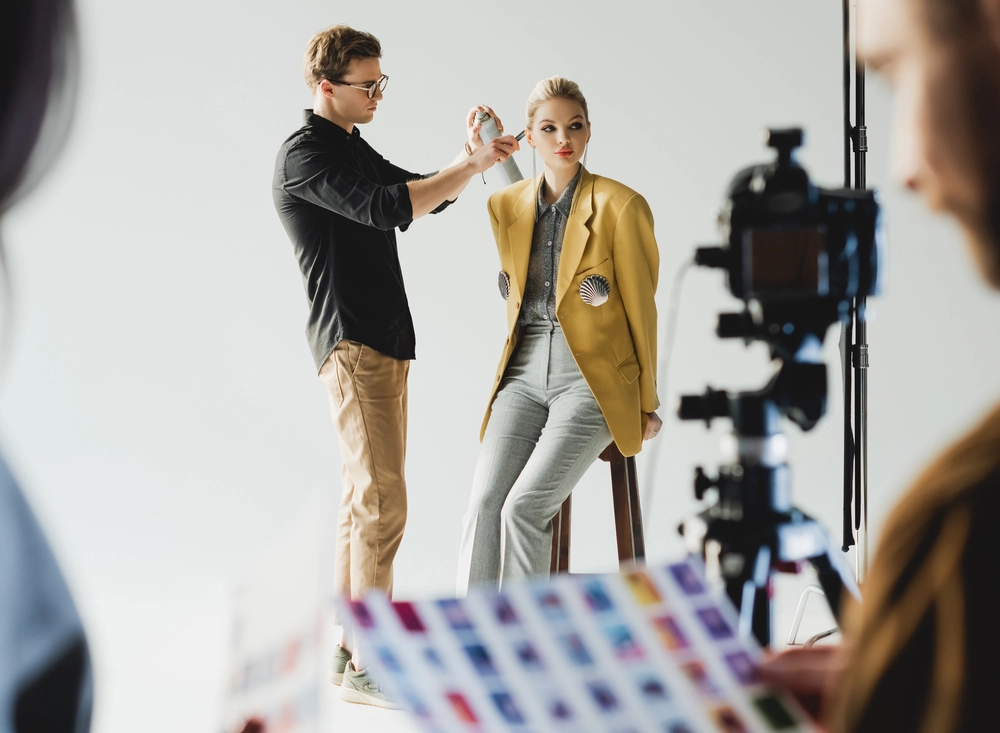 modèle se fait recoiffer dans un studio photo lors d'un shooting